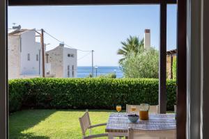 a table with two glasses of orange juice on a patio at Villa Avra in Panormos Rethymno