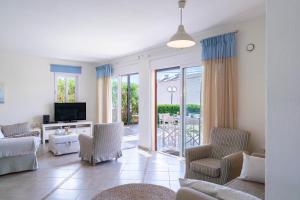 a living room with a couch and chairs and a television at Villa Avra in Panormos Rethymno +91 photos