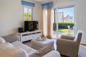 a living room with a couch and a tv at Villa Avra in Panormos Rethymno