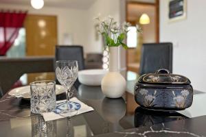 a table with glasses and a vase on it at Finikas Garden Home in Karianí +24 photos