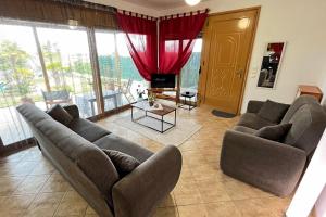 a living room with two couches and a large window at Finikas Garden Home in Karianí