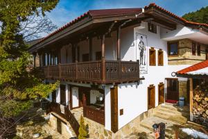 a house with a balcony on the side of it at Разбойна in Zheravna