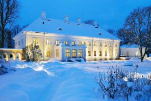 a large white house in the snow at night at Anija mõis in Anija +26 photos