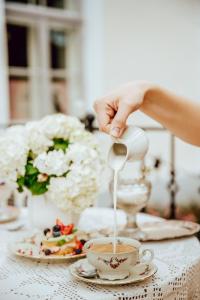 a person pouring coffee into a cup on a table at Anija mõis in Anija