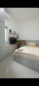 a white bedroom with a bed and a kitchen at Sukabumi Villa Mochi Private Jacuzzi in Sukabumi