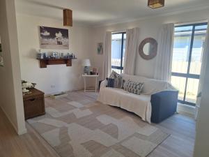 a living room with a couch and a large window at Helens Hideaway in Coronet Bay