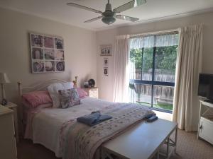 a bedroom with a bed with a table and a window at Helens Hideaway in Coronet Bay