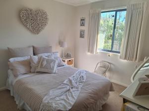 a bedroom with a bed with a heart on the wall at Helens Hideaway in Coronet Bay