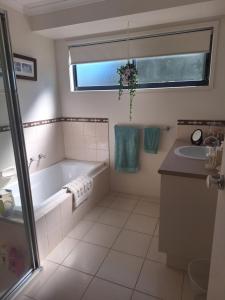 a bathroom with a tub and a sink at Helens Hideaway in Coronet Bay