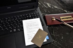 a laptop computer with a book and a pen at ホテルマルセイユ in Shimoda