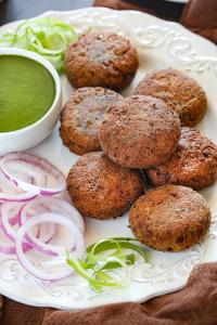 a plate with muffins and a bowl of green dipping sauce at Hotel Silver Dragon, NK Darranga in Darranga