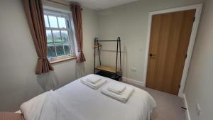 a bedroom with a bed with two towels on it at Gardeners Cottage Apartment in Tyberton +20 photos