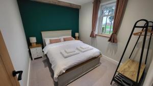 a bedroom with a bed with a green wall at Gardeners Cottage Apartment in Tyberton