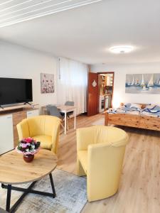 a living room with yellow chairs and a table at Ferienwohnung Iris in Radolfzell am Bodensee
