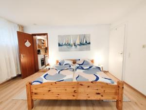 a bedroom with a bed and a painting of sailboats at Ferienwohnung Iris in Radolfzell am Bodensee