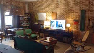 a living room with a tv and a brick wall at Virgínia Palace in Corumbá
