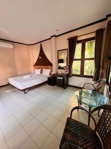 a bedroom with a bed and a table in a room at IYARA b in Ban Map Khangkhao