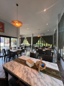 a dining room with tables and chairs and a restaurant at IYARA b in Ban Map Khangkhao