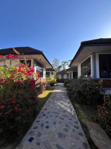 a walkway in front of a house with flowers at IYARA b in Ban Map Khangkhao