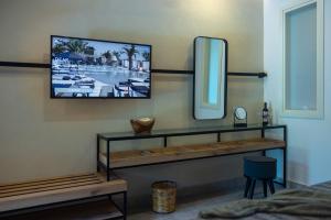 a room with a television on a wall at Eliros Mare Beachfront Poem Hotel in Georgioupolis