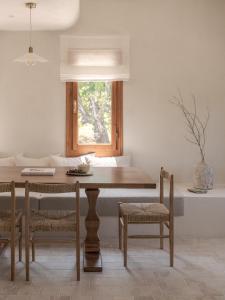 a dining room with a table and chairs and a window at Om Living Pelion in Agios Dimitrios +66 photos