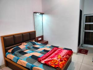 a bedroom with a bed with a blanket on it at Hotel Keshav in Rīngas