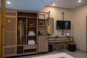 a room with a desk and a tv on a wall at Eliros Mare Beachfront Poem Hotel in Georgioupolis