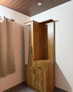 a wooden cabinet in the corner of a room at Pebbles in Thirunelli +15 photos
