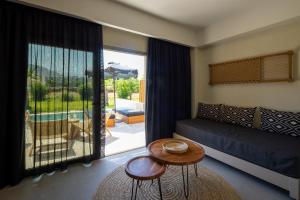 a living room with a couch and a table at Eliros Mare Beachfront Poem Hotel in Georgioupolis