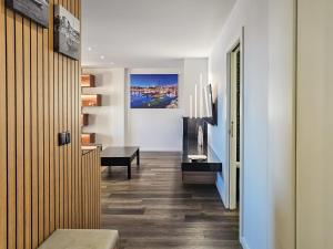 a hallway with white walls and wooden flooring at Ocean Breeze - Comfortable Ap Close to the Beach in Bicas