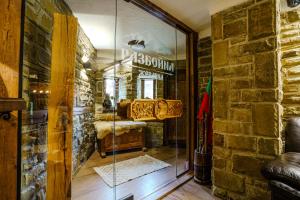 a room with a stone wall and a glass doorway at Разбойна in Zheravna +91 photos