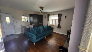 a living room with a blue couch and a table at Gardeners Cottage Apartment in Tyberton