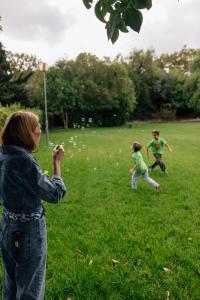 a woman taking a picture of two children flying a kite at M'AR De AR Muralhas in Évora