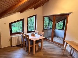 a dining room with a table and chairs and windows at Neumühle Saar in Mettlach