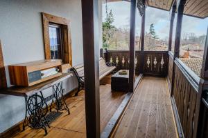 a porch with a wooden deck with a bench on it at Разбойна in Zheravna