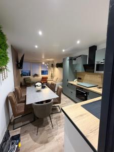 a kitchen and living room with a table in a kitchen at Family in Calais
