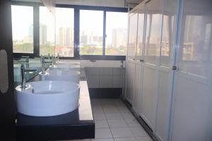 a bathroom with four sinks and a row of toilets at YMCA of Manila Hostel in Sampong