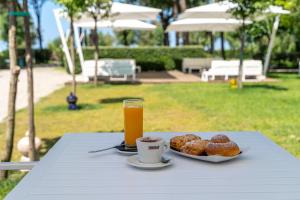 a table with a plate of donuts and a glass of orange juice at Otium Mare Felix in Stazione di Paestum +14 photos