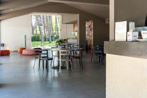 a restaurant with tables and chairs and a large window at Otium Mare Felix in Stazione di Paestum