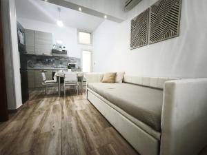 a white living room with a couch and a table at B&B Ampelea in Gallipoli