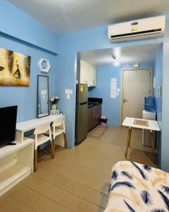 a living room with blue walls and a kitchen at Henry's Newport Condotel in Manila