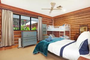 a bedroom with a bed and a wooden wall at The Lodge at Eagle Rock Farm, in Mandemar