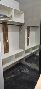 an empty closet with white shelves in a room at Kitnet próximo ao shopping in Campo Grande +7 photos
