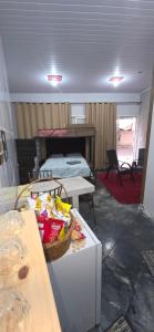 a room with a bed and a table with a basket at Kitnet próximo ao shopping in Campo Grande