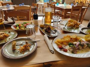 a wooden table with plates of food on it at Galini Stone House in Proástion