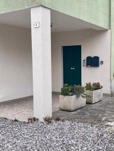a blue door on a building with two plants at LA CASETTA - Clusone in Clusone