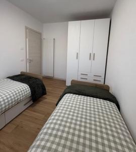 a bedroom with two beds and white cabinets at LA CASETTA - Clusone in Clusone