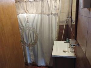 a bathroom with a white shower curtain and a sink at Cabaña María Lourdes in Maipú +12 photos