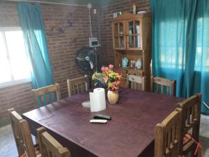 a dining room table with a vase of flowers on it at Cabaña María Lourdes in Maipú