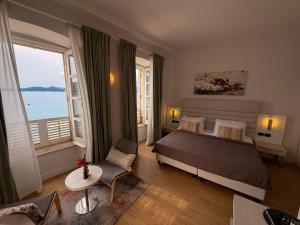 a bedroom with a bed and a large window at La Villa Lopud- Breakfast & Dinner Included in Lopud